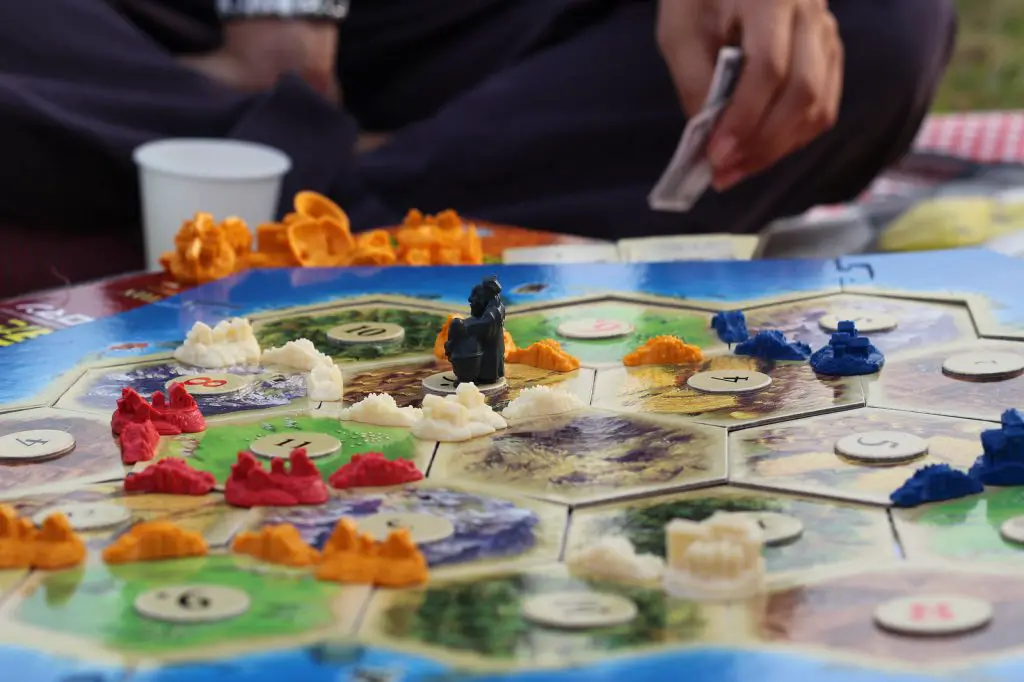 Close up on people playing Settlers of Catan